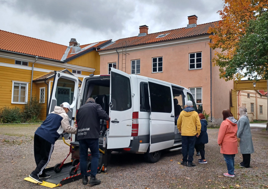 Rollatoria käyttävä henkilö menossa luiskan avulla autoon. 